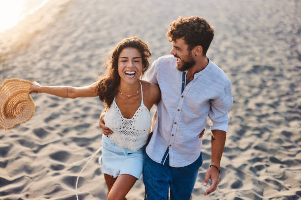 istock Happy couple enjoying in summer walk on the beach. 2157229886