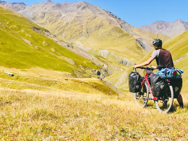 istock Back view cyclist push touring bicycle uphill to mountain. Atsunta pass trekking route on bicycle 2157230950