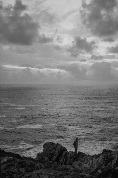 istock Man standing on the rocks by the beach 2157232790