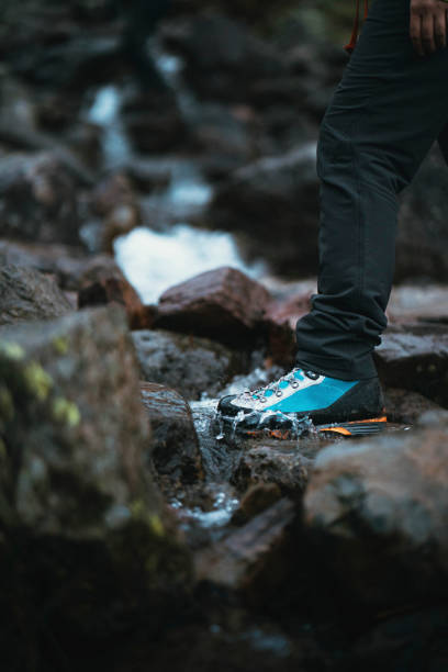istock Woman crossing the rocky stream 2157233292