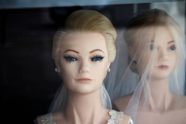 Mannequin Head wearing a pink vintage hat. Next to the mannequin head is a  vintage pink clock.