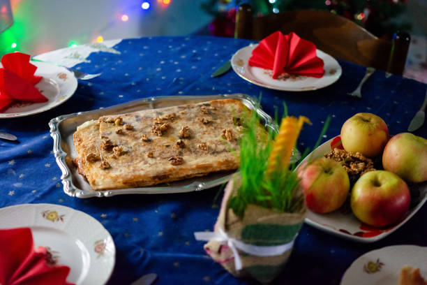 Traditional food for orthodox Christmas at the table. Christmas cake whit walnuts and wheat whit candle