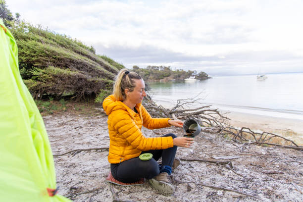 istock Woman Camping on Secluded Beach with Green Tent 2157241345