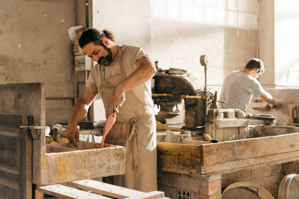 istock Men Mixing Color Paste and Working in a Busy Hydraulic Tile Workshop During Daytime 2157243832