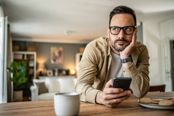 istock Portrait of a middle-aged man using a smartphone at home 2157244068