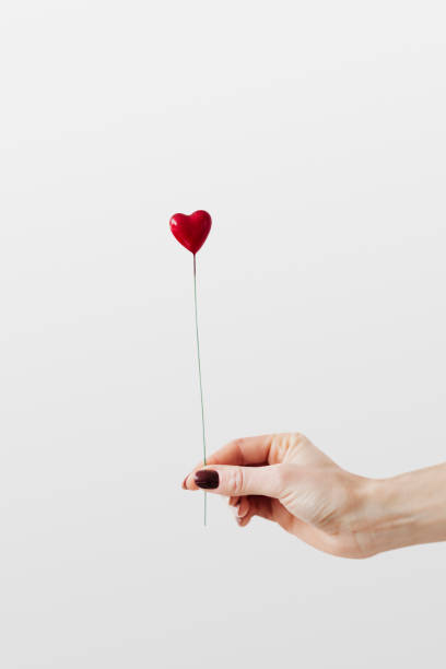istock Woman holding a red heart on a stick 2157245021