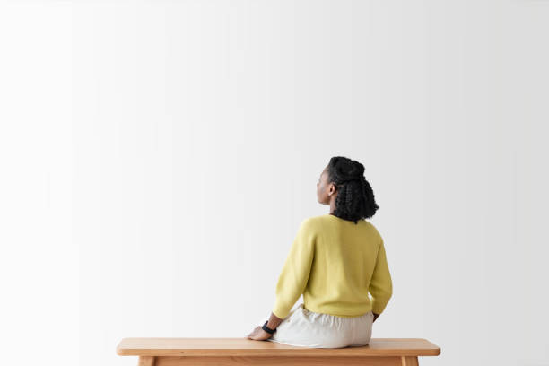 Woman looking at blank wall rear view