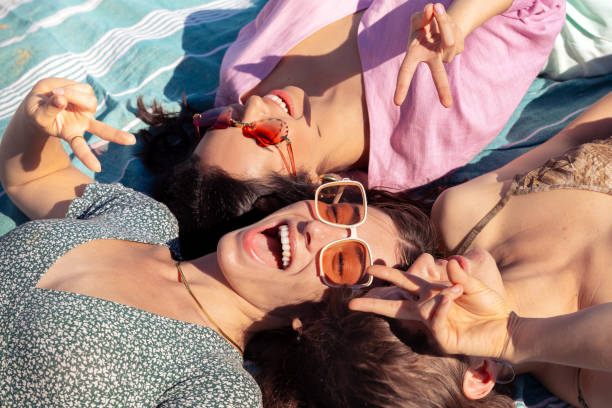 istock Three young women sunbathing on beach towels on the sand 2157248150