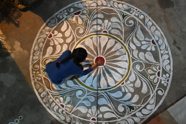 A woman drawing kolam/rangoli in front of a Temple in Bengaluru