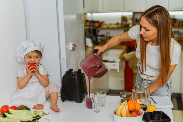 istock Mother Feeling Proud Of Teaching Her Small Daughters How To Make Smoothies 2157249884