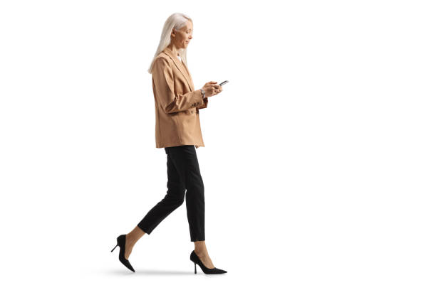 istock Professional woman walking and typing on a mobile phone 2157249916
