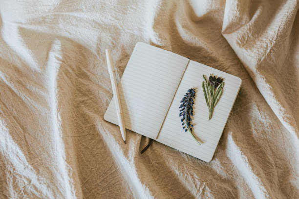 istock Open notebook with flowers and pen on linen blanket 2157250437