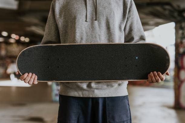 istock Skater holding black skateboard, closeup 2157252110