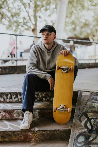 istock Skater sitting on steps with wooden skateboard 2157252162