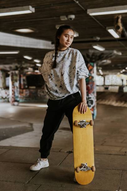 istock Cool Asian skater with wooden skateboard 2157252179