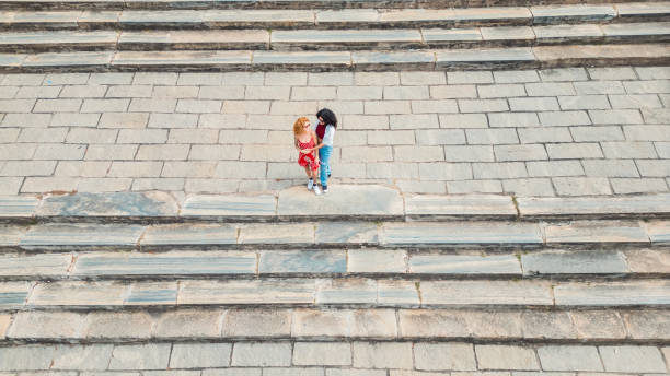 Two well dressed professionals in discussion on the exterior steps of a courthouse. Could be lawyers, business people etc.