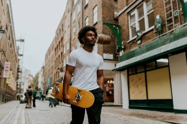 istock Man walking in town with wooden skateboard 2157253962