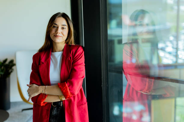 istock Confident young professional in red blazer smiling at modern office environment 2157254237