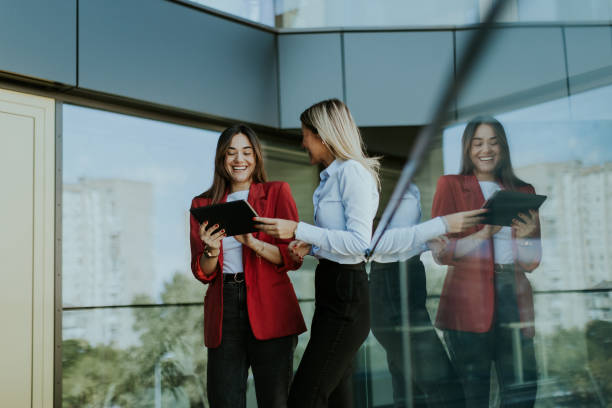 istock Two business women collaborating outdoors with digital tablets on a sunny afternoon 2157254367