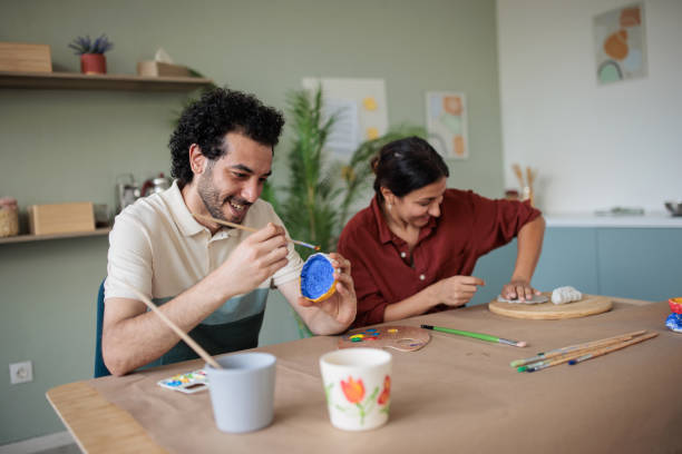 istock Two friends making clay bowls at home 2157255502