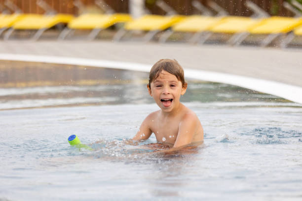 Cute child, boy in water park, having fun summertime together with brothers