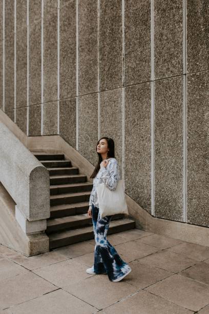 istock Woman by staircase, using white tote bag 2157255834