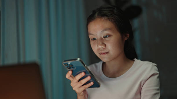 istock Teenager student talking with a voice assistant on smartphone at night. 2157256515