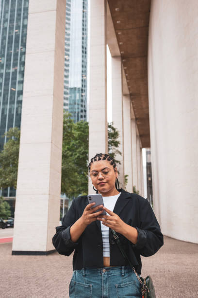 istock Woman standing and using mobile phone 2157258117