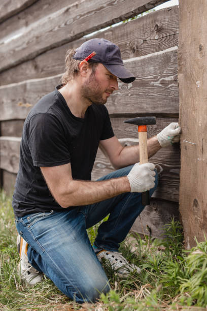 istock A man builds a wooden fence from boards 2157259864
