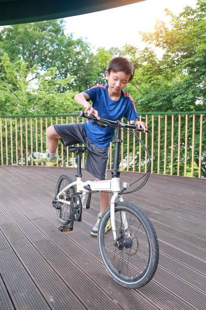 istock Boy riding white bicycle in the city park 2157262593
