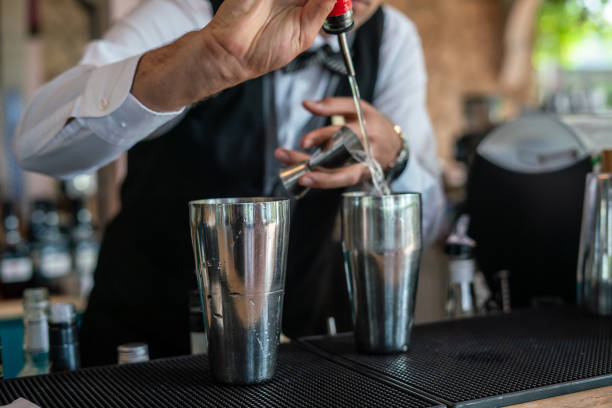 istock bartender is preparing cocktail at bar putting alcohol at stell shaker horizontal food and beverage still 2157263456