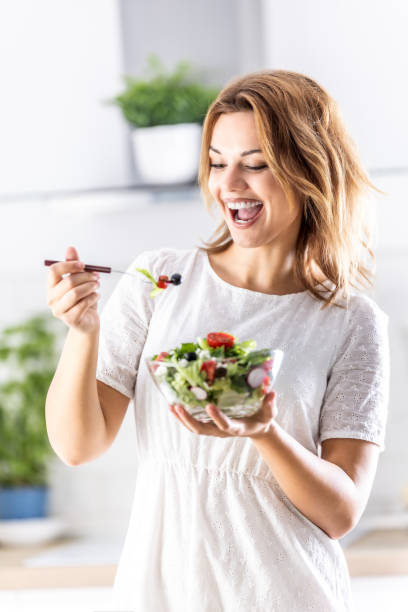 istock Young cute lady enjoys eating healthy salad. 2157264342