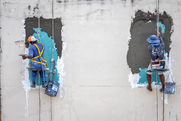 Salvador, Brazil – December 19, 2024 : two workers hanging roped up at facade in Salvador da Bahia, Brazil