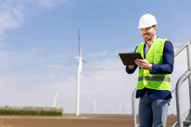 istock Smiling Engineer With Tablet Inspecting Wind Turbines On A Sunny Day 2157270491