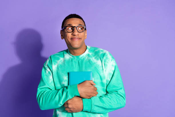 istock Photo of dreamy guy dressed turquoise sweatshirt spectacles hold book look empty space isolated violet color background 2157273811