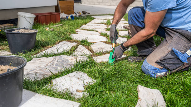 istock Gardening. A man makes a footpath in the grass from travertine rustic stone. 2157275873