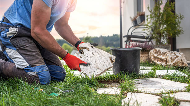 istock Gardening. A man makes a footpath in the grass from travertine rustic stone. 2157276531