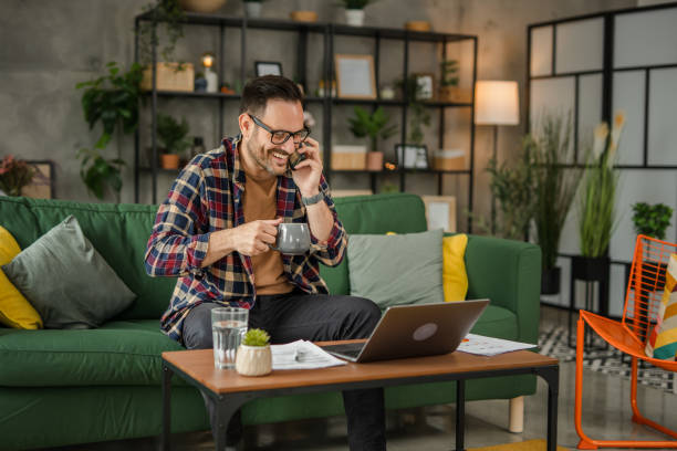 istock One business men sitting and working from home, talking on a mobile phone, using technology concept 2157278318