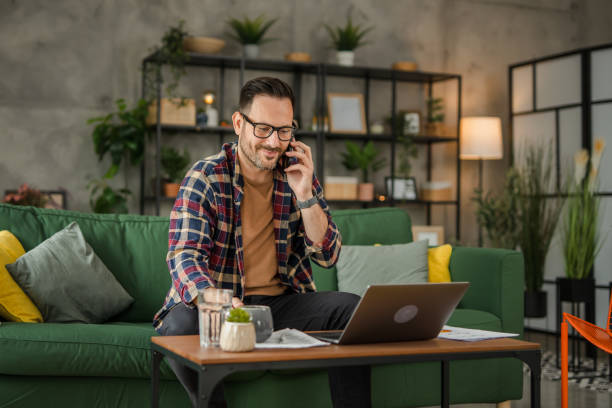 istock One business men sitting and working from home, talking on a mobile phone, using technology concept 2157278339