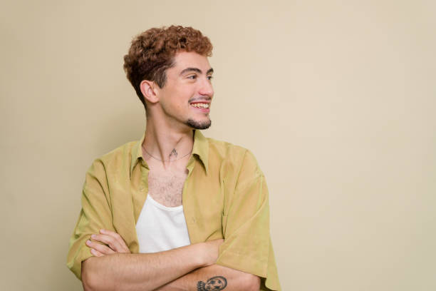 istock Young man with crossed arms smiling and looking away 2157278422
