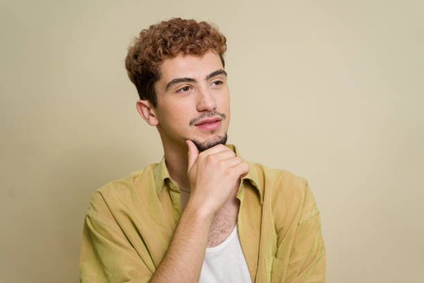 Young man with curly hair deep in thought
