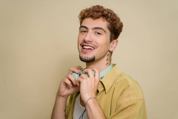 istock Happy young man putting on headphones smiling at home 2157278607