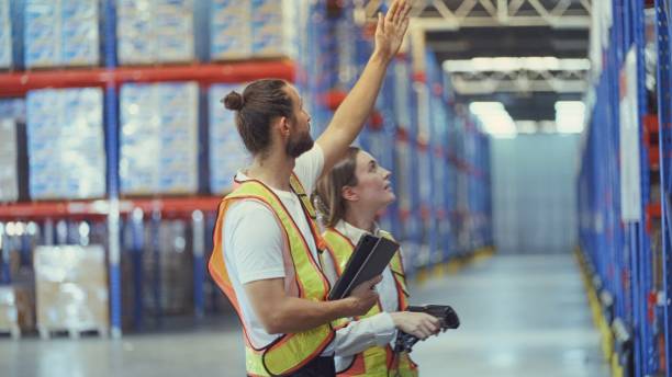 istock Professional engineering team inspect safety of shelving, storage systems and equipment used to lift and move pallets in the warehouse. Employees daliverry check items according to program to be shipped on tapelets. Logistics, transportation. 2157282678