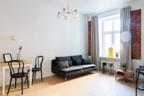 istock Studio apartment with sofa near window, table, chair and design indoors architecture. Interior decor. 2157285850
