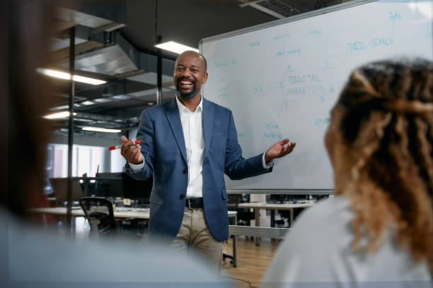 istock Three happy multiracial colleagues smiling next to whiteboard during meeting in office 2157287955