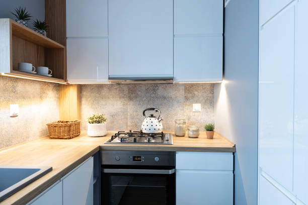 istock Modern kitchen in bright interior with wooden countertop, oven with kettle and pattern tile on the wall. Home decor. 2157288045