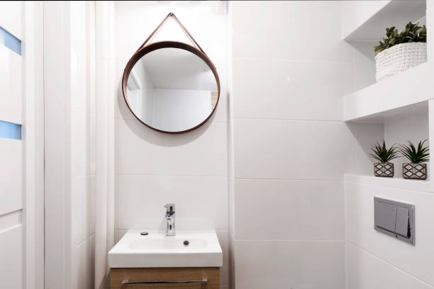 istock Home interior of modern bathroom with ceramic sink on cupboard , and circle mirror on the wall. Elegance and luxury in apartment. 2157288114