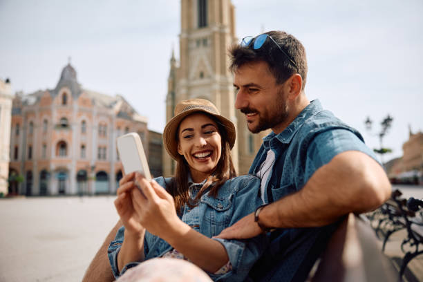 istock Young happy couple using cell phone in the city. 2157290995