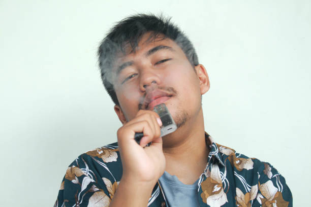 istock Young Asian man holding a vape or e-cigarette vaping device. quitting smoke concept. 2157291072