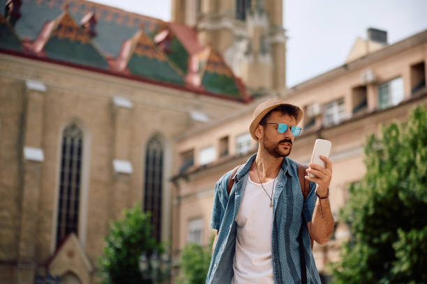 istock Young man using app on mobile phone while walking on the street. 2157291760